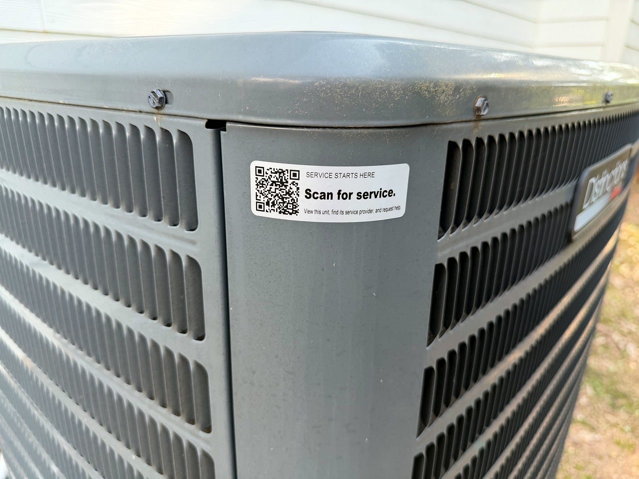 Tech Was Here QR service tag on the fixed panel of an outdoor HVAC condenser