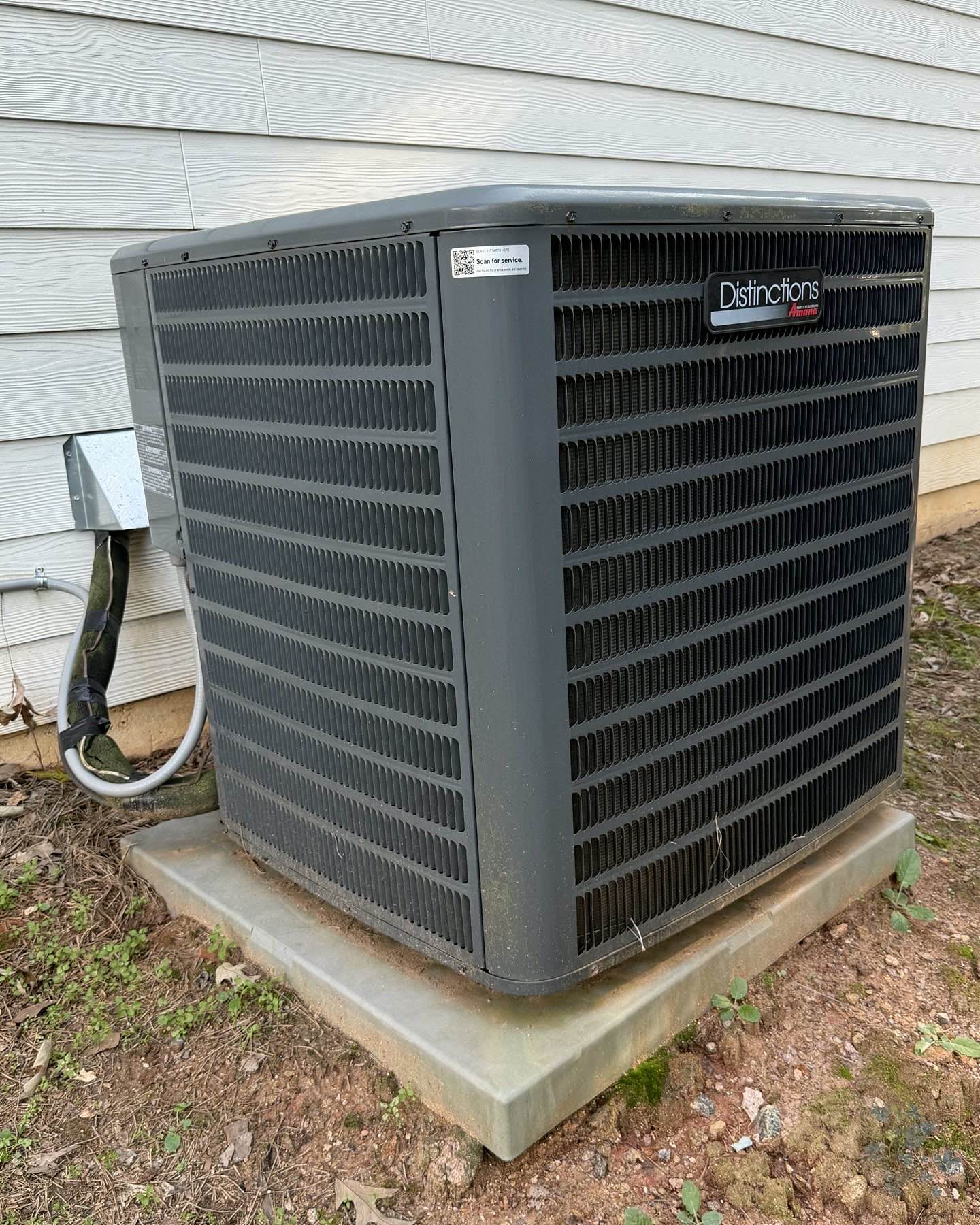 Outdoor HVAC condenser with a Tech Was Here QR service tag placed on a visible fixed panel