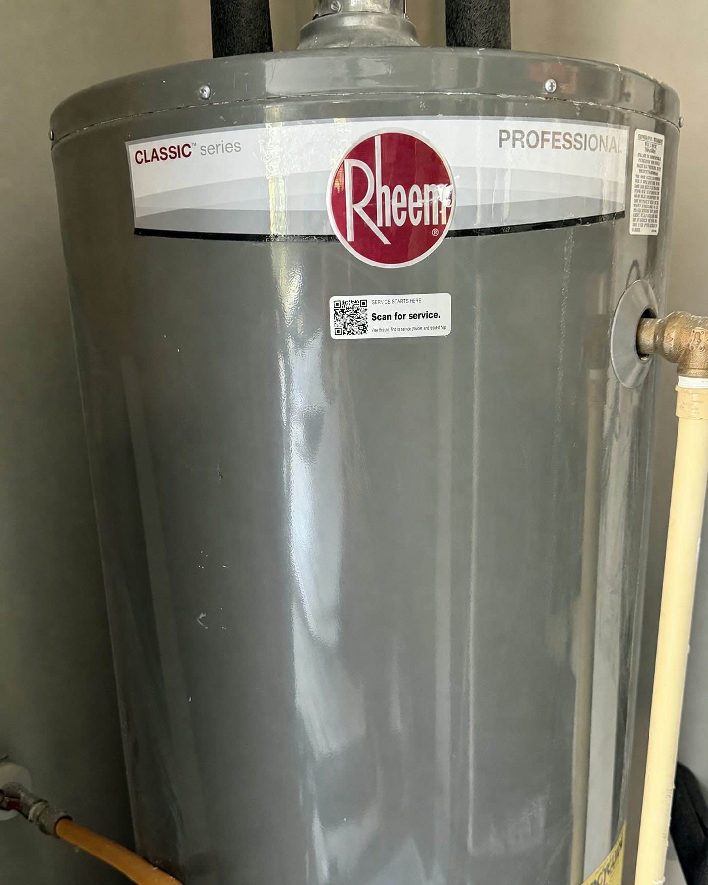 Tech Was Here QR service tag installed on the outer jacket of a residential water heater